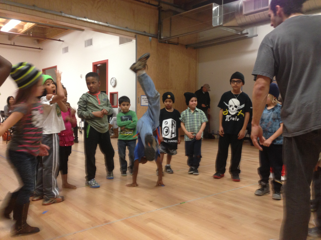 Drew Looner watches a student balance on their hands with one leg raised during a breaking class at Destiny Arts in Oakland.