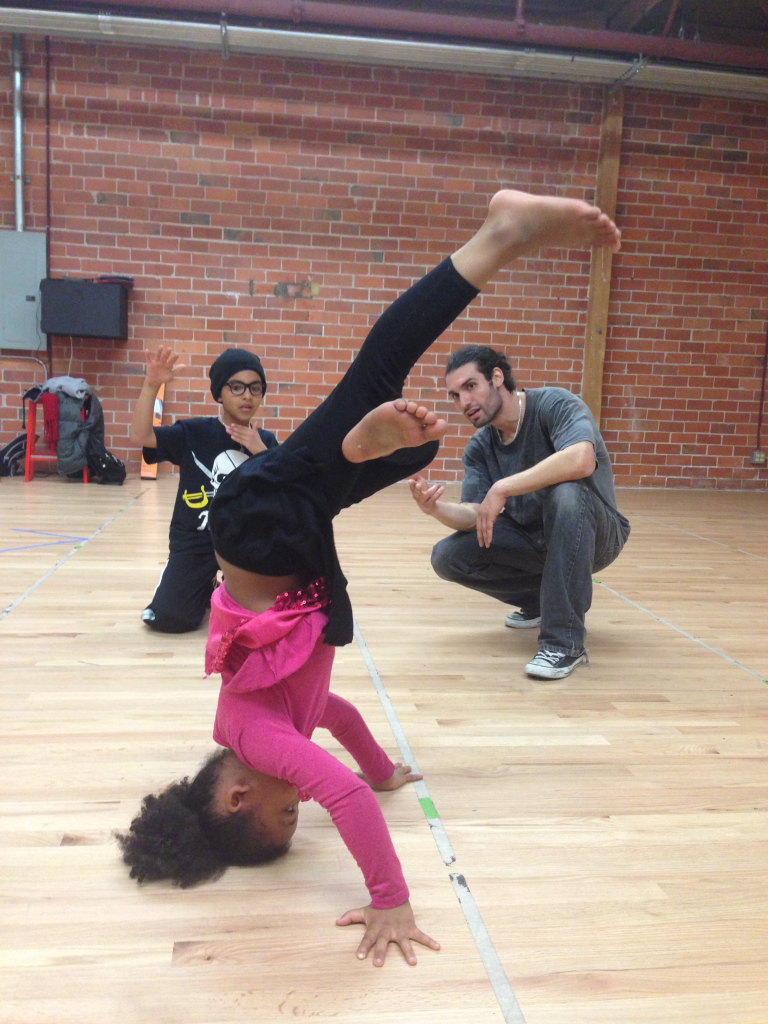 Drew Looner coaches a student practicing a headstand during a breaking class at Destiny Arts in Oakland.